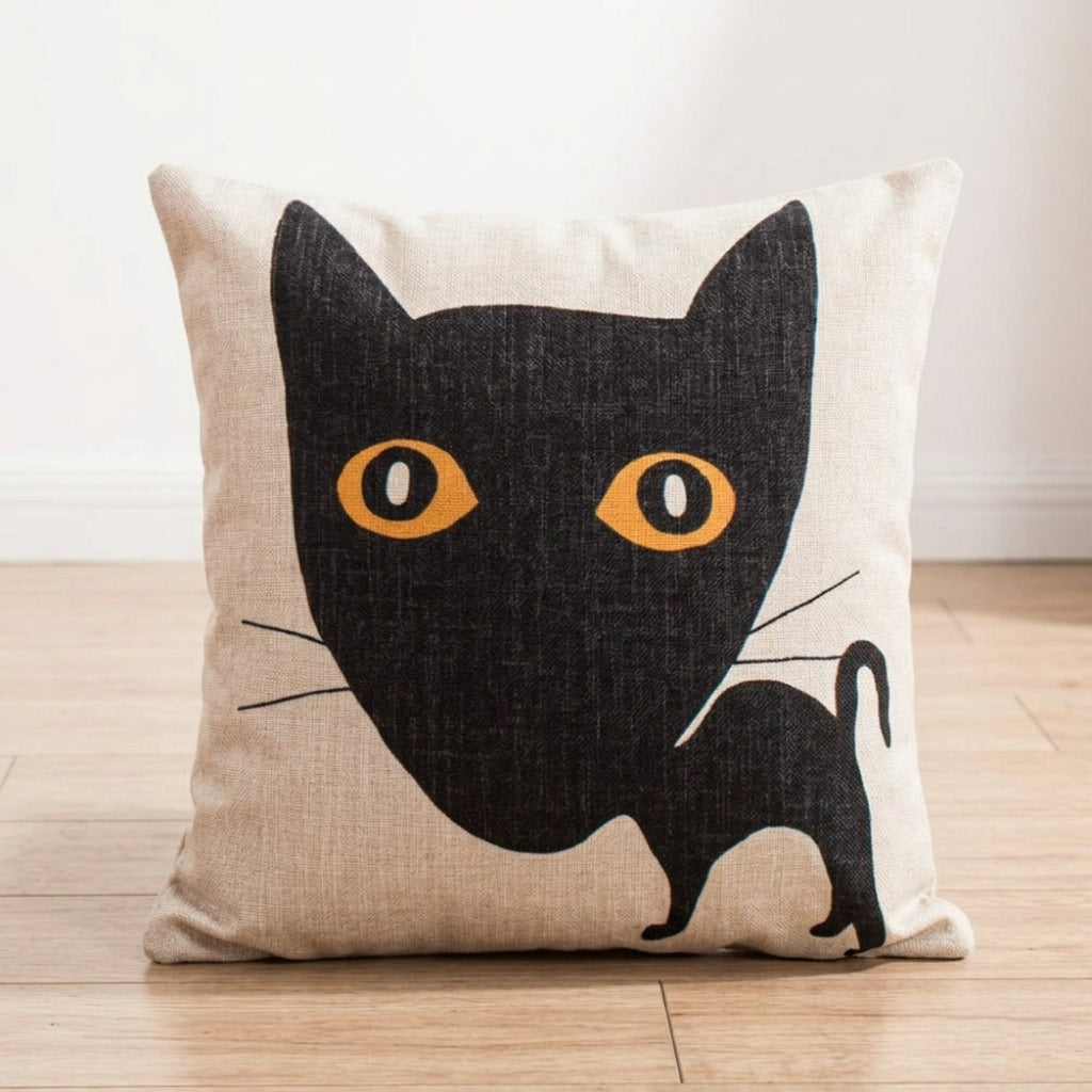 Cream cushion cover with a black cat and large yellow eyes.