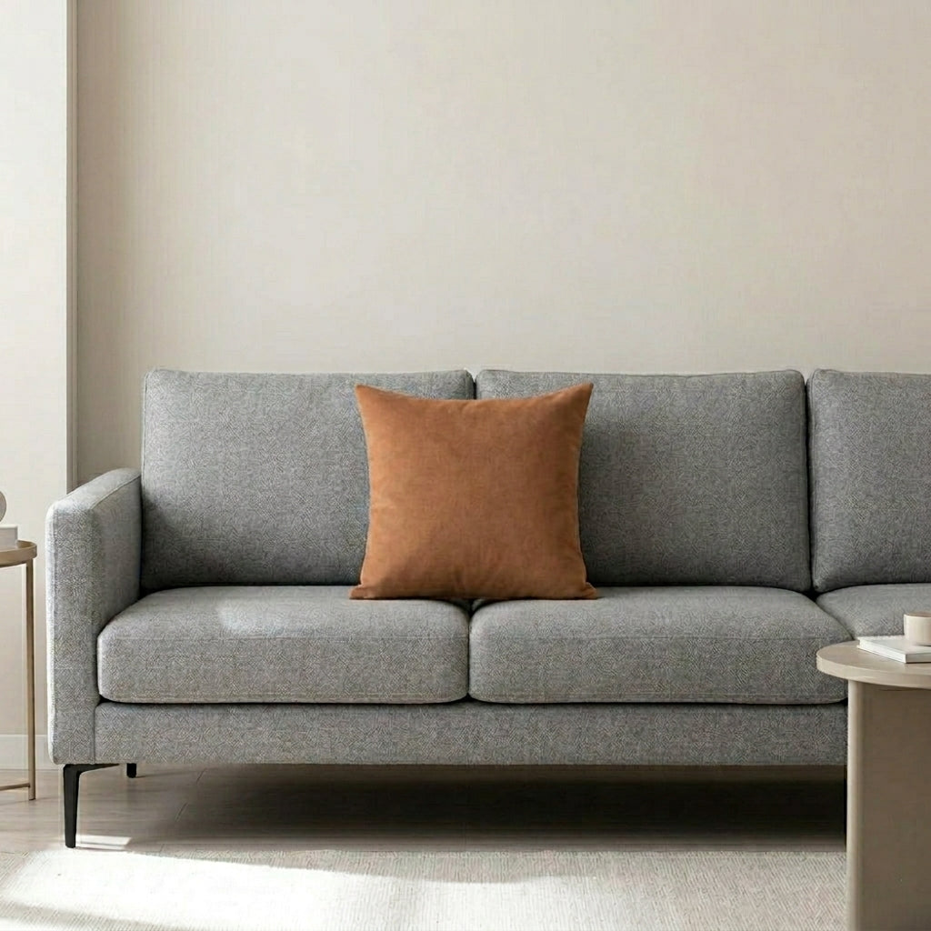 Plain warm brown cushion cover on a grey sofa.