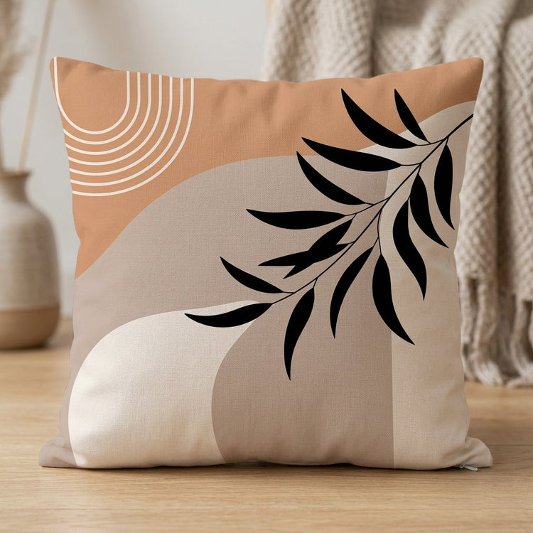 Peach and cream cushion cover with a black leafy branch and fine curved line details.