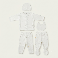 A baby clothing set laid flat on a light cream background, including a long-sleeve button-front top, matching footed pants, a bib, and a small hat. The garments are white with tiny scattered pastel animal prints.