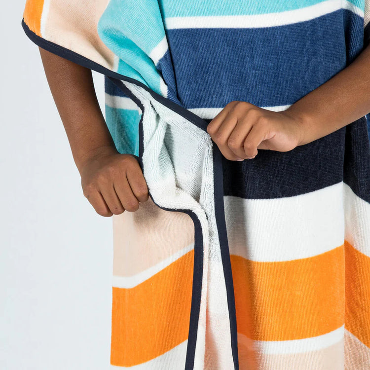 Close-up of the side opening and striped fabric of a towel poncho.