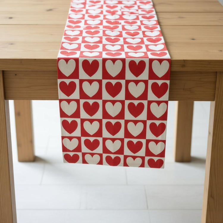 Red and cream table runner with repeating heart-shaped motifs.