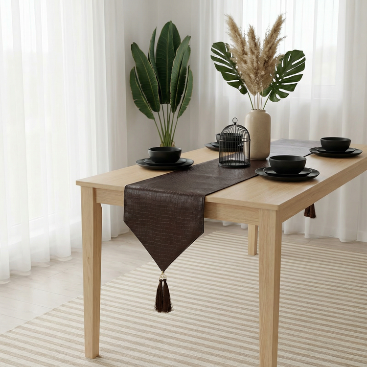 Dark brown textured table runner with a pointed tasselled end.