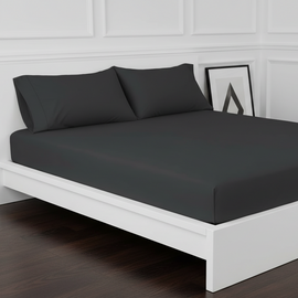 Black cotton fitted sheet displayed on a double bed with matching pillowcases.