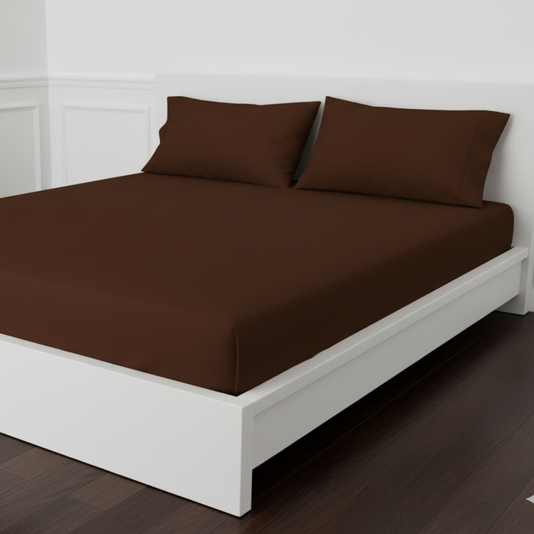 Chocolate brown fitted sheet displayed on a bed with matching pillowcases.