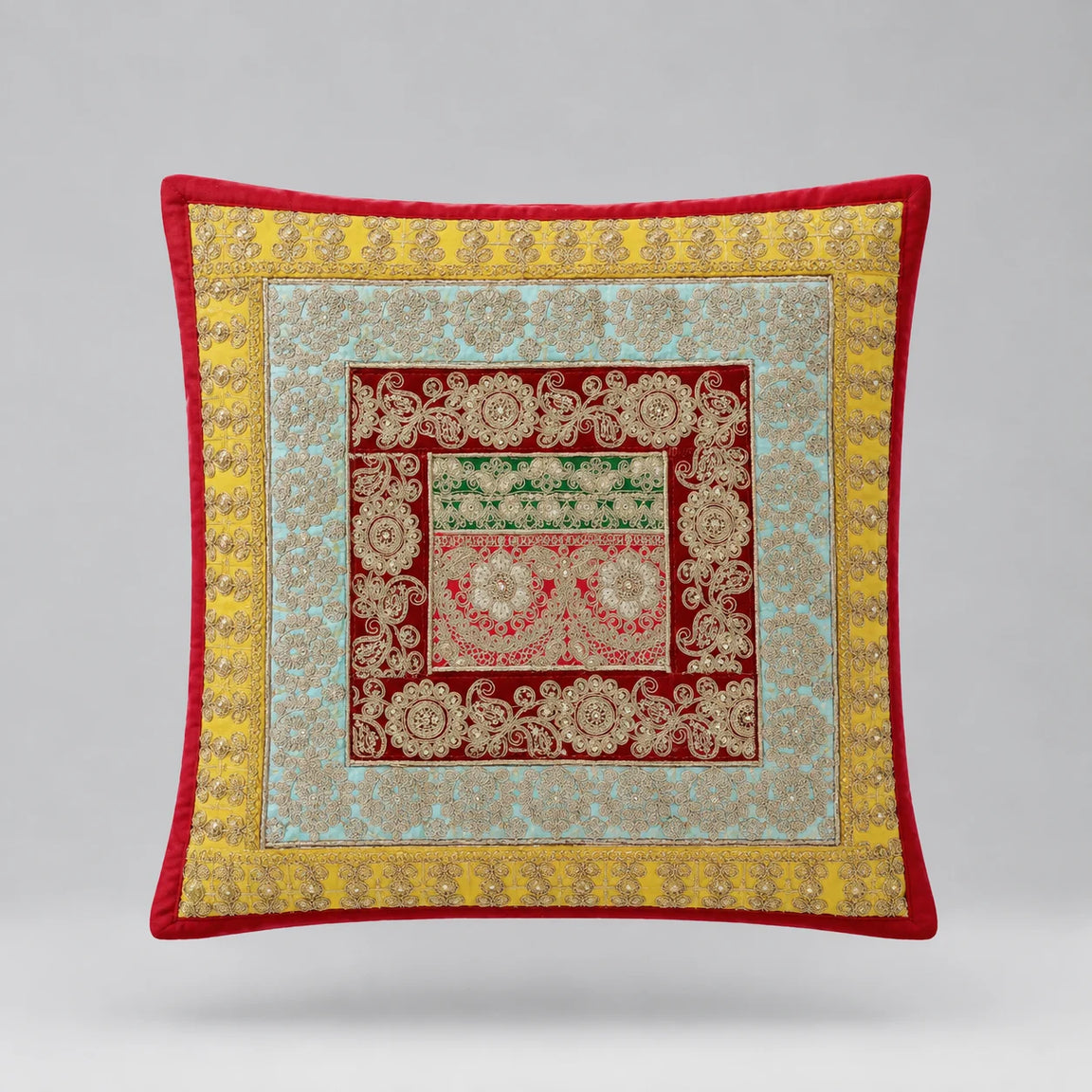 Red-bordered cushion cover with yellow and pale green floral borders around a patterned red centre.