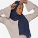 Model wearing a plain navy chiffon stole as a headscarf.