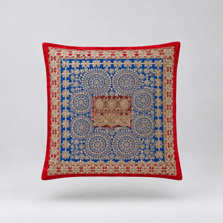 Red-bordered cushion cover with a dense blue ornamental pattern and small brown central panel.