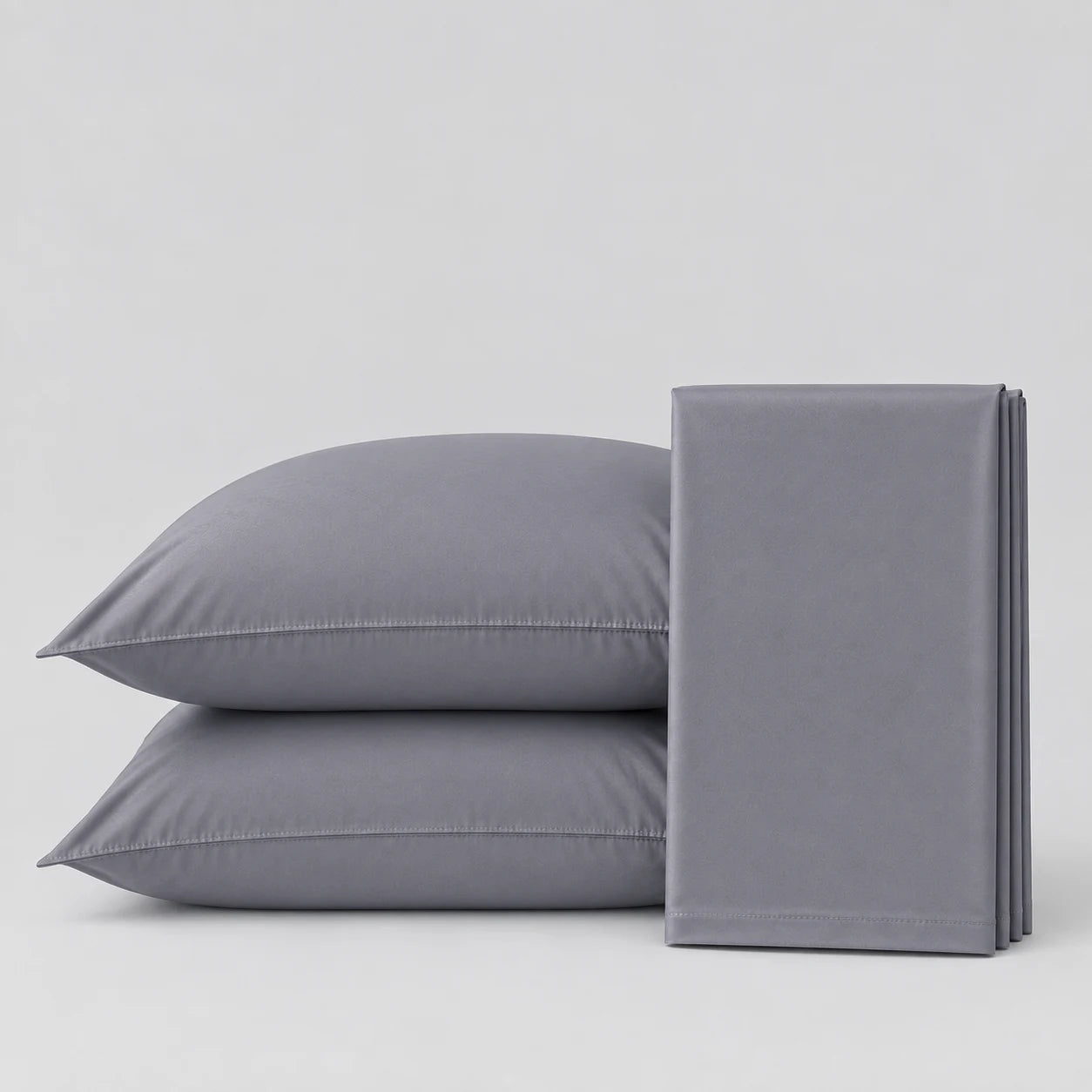 Two gray pillowcases stacked on the left and a folded matching gray pillowcase on the right, photographed on a clean light gray studio background.