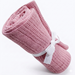 Rolled rose-pink cellular blanket tied with a white ribbon.