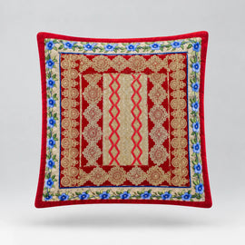 Red-bordered cushion cover with ornate blue and gold coloured bands around a red patterned centre.