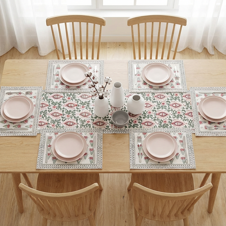 Cream floral table runner with muted pink and green motifs and matching placemats.