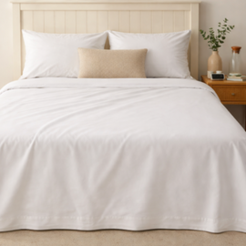 Plain white cotton thermal blanket spread across a bed.