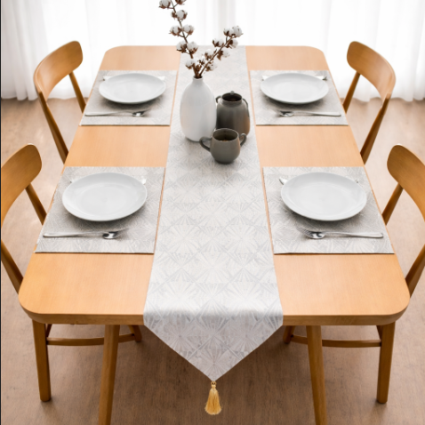 Silver-grey patterned table runner and matching placemats on a set table.