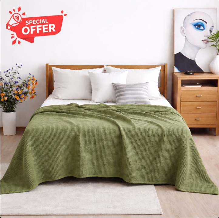 Olive green cotton thermal blanket draped over a bed.