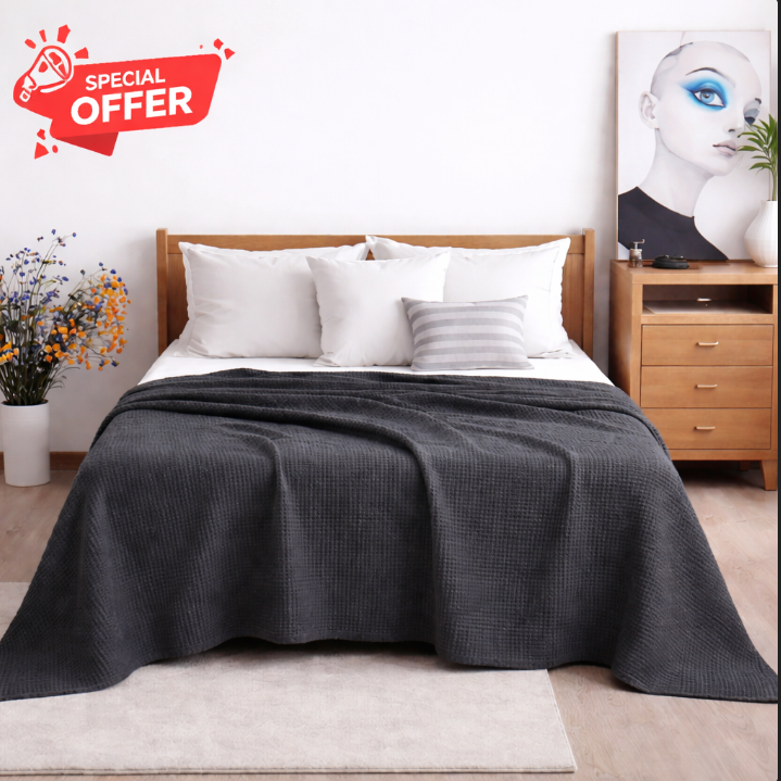 Charcoal grey cotton thermal blanket draped over a bed.