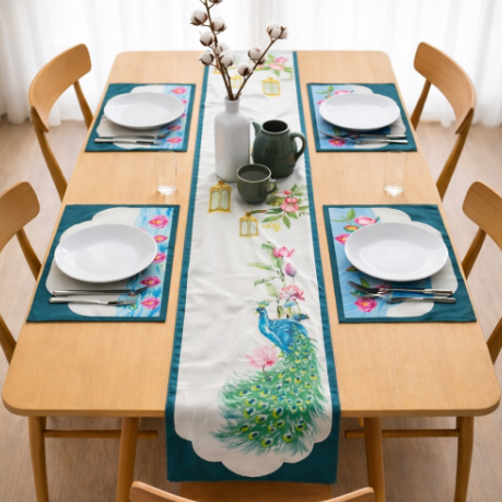 Cream peacock-print table runner with teal borders and matching placemats.