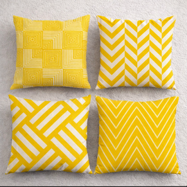 Four yellow and white cushion covers with square, chevron and diagonal geometric patterns.