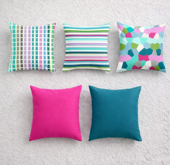 Five cushion covers with colourful stripes and abstract shapes plus plain pink and teal designs.