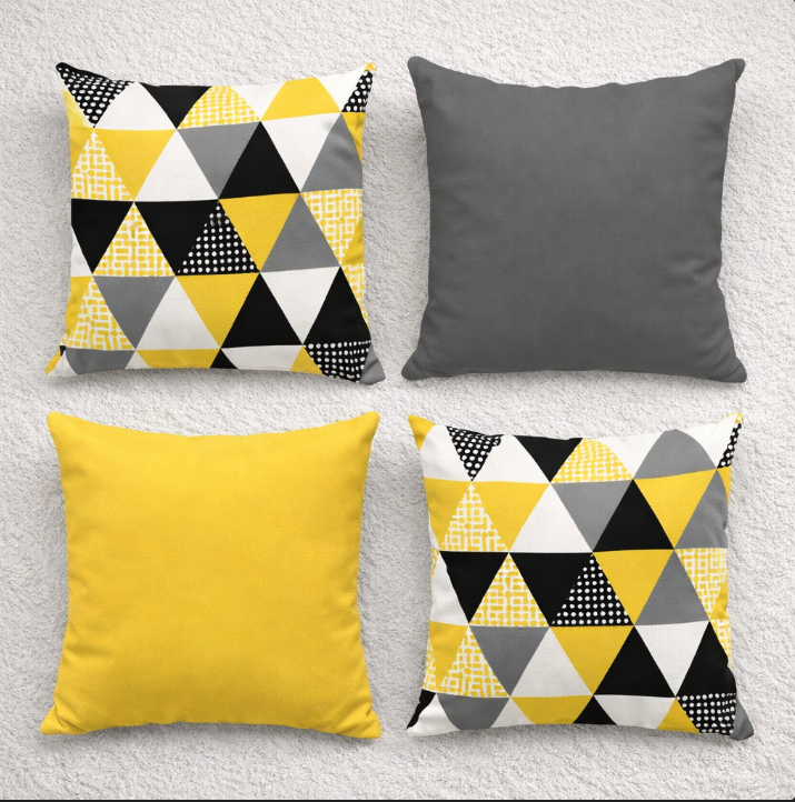 Four cushion covers in yellow, grey and black with plain and triangle patterns.