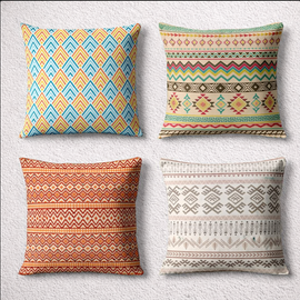 Four cushion covers with colorful chevrons, diamonds and geometric bands, arranged in a two-by-two grid.