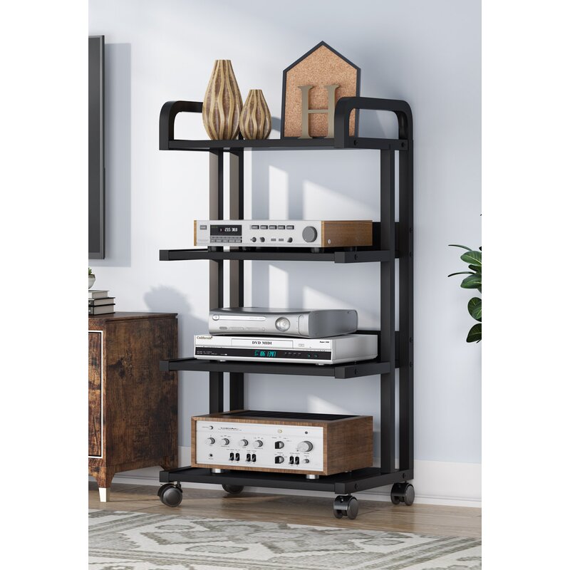 Four-tier rolling rack with a black frame and brown shelves holding audio and media equipment beside a television.
