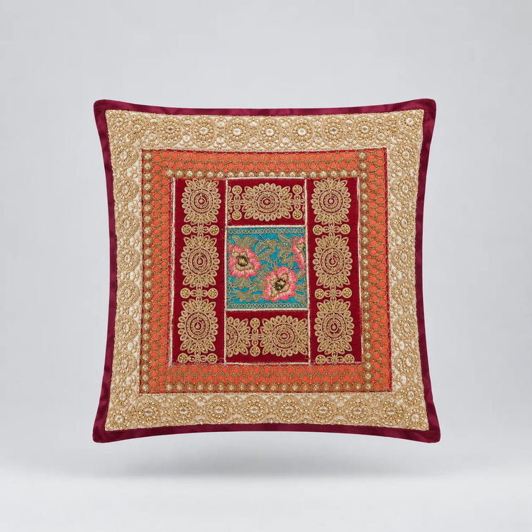 Burgundy-bordered cushion cover with pale gold coloured and red frames around a teal floral centre.