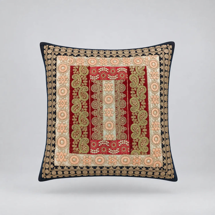 Dark-bordered cushion cover with ornate red, cream and pale gold coloured rectangular panels.