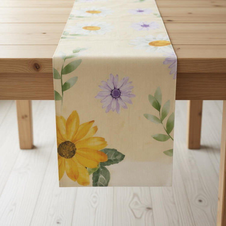 Pale yellow table runner with large yellow and purple flowers.