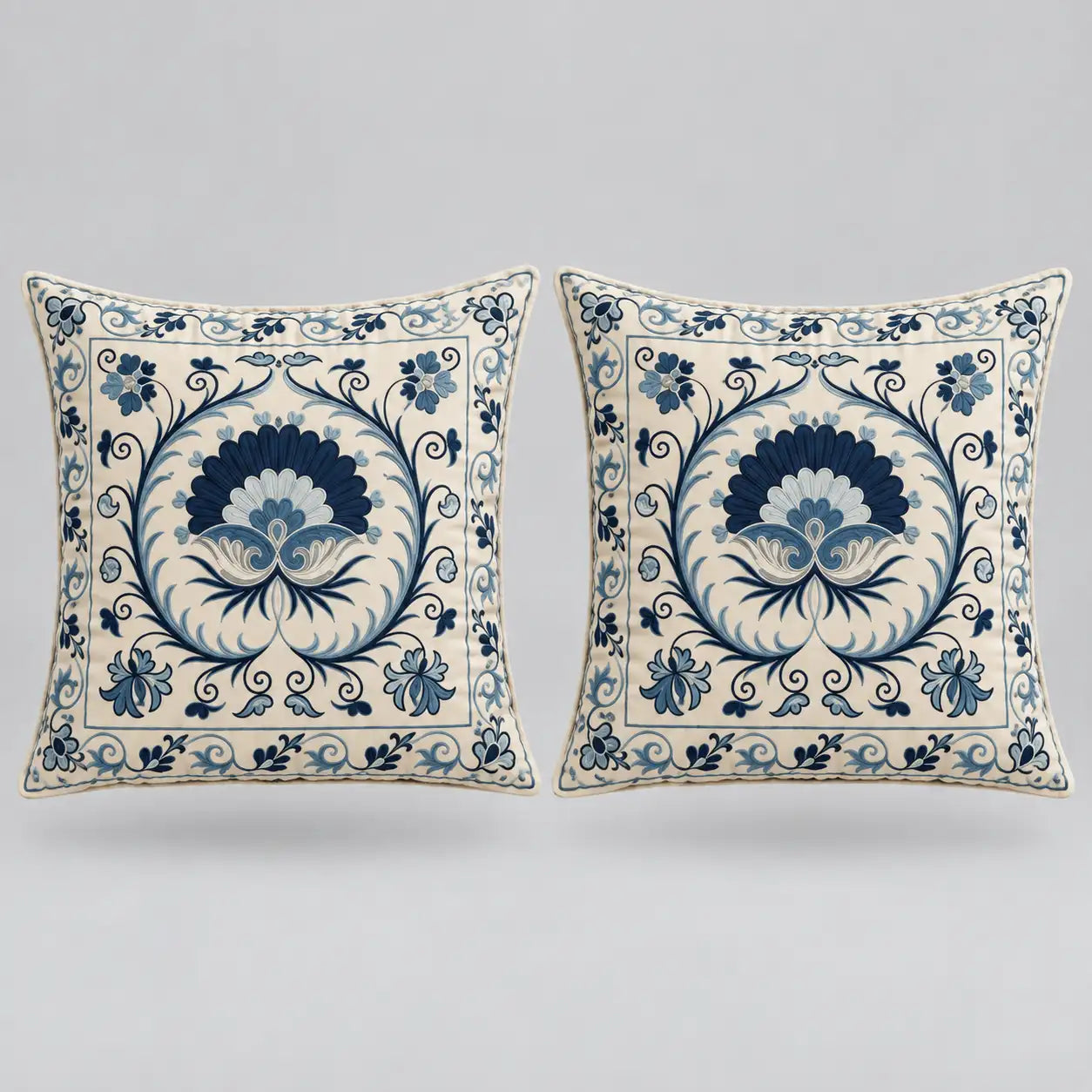 Two square decorative throw pillows with a blue and cream floral damask pattern, displayed side-by-side against a neutral light gray background.