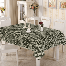 Cream and dark green geometric tablecloth on a dining table.
