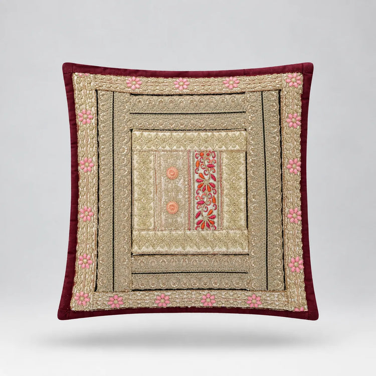Burgundy-bordered cushion cover with layered beige and black geometric borders and pale floral details.