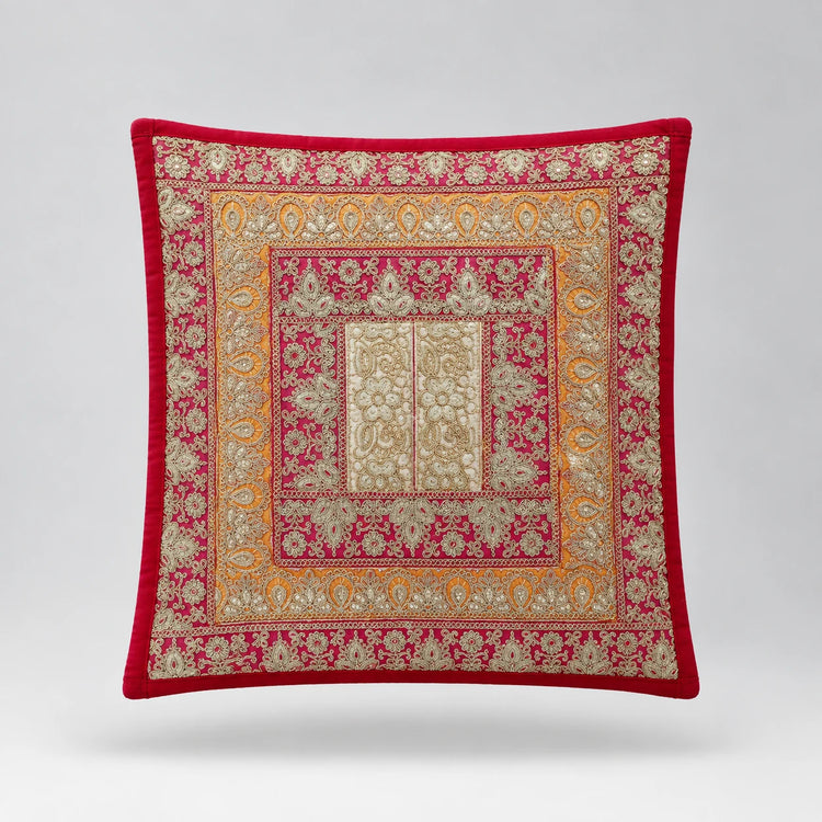 Red-bordered cushion cover with pink and gold coloured ornamental frames around a pale centre.