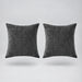 two gray velvet cushions floating on a light grey surface
