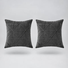 two gray velvet cushions floating on a light grey surface