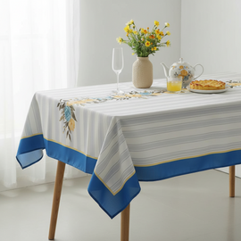 White and pale blue striped tablecloth with a wide blue border and floral accents.