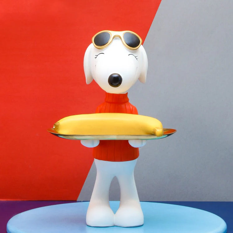 White dog figurine in a red top holding a gold-coloured tray.