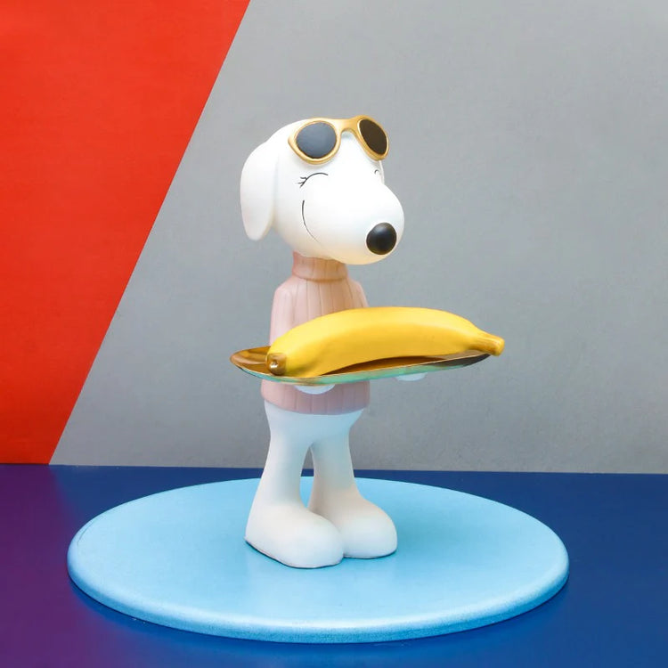 Side view of a white dog figurine holding a gold-coloured tray.