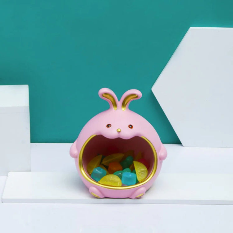 Pink rabbit-shaped organizer holding small colourful objects in its open compartment.