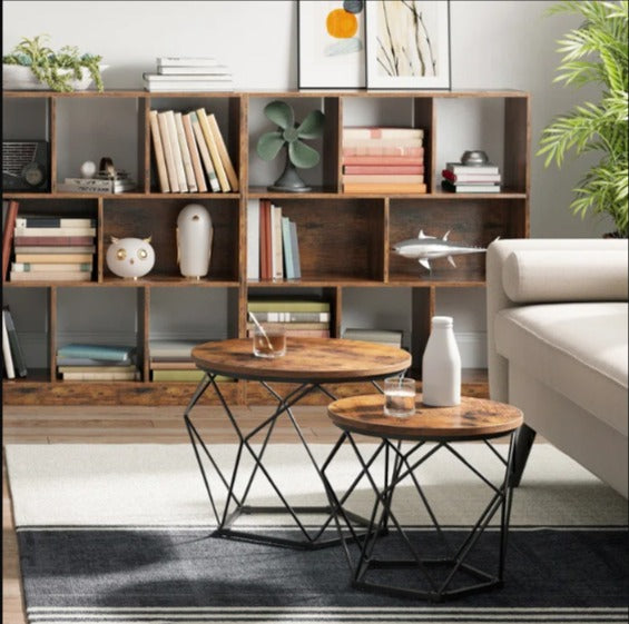 Two round brown nesting coffee tables with angular black wire bases in a living room.