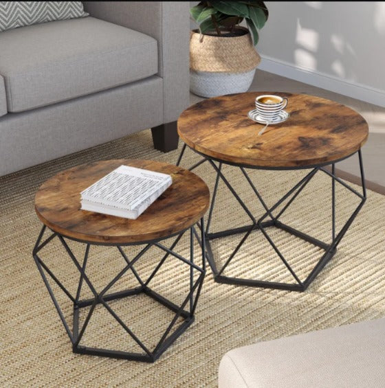 Overhead view of two round brown coffee tables with geometric black wire frames beside a sofa.