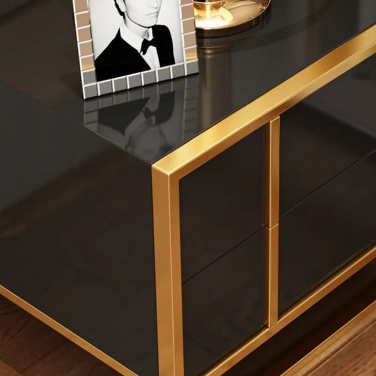 Close-up of a glossy black bedside cabinet top and gold-colored corner trim.