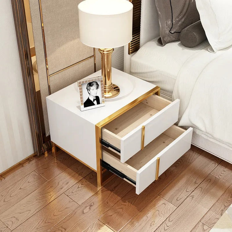 White bedside cabinet with both drawers open beneath a lamp and framed photograph.