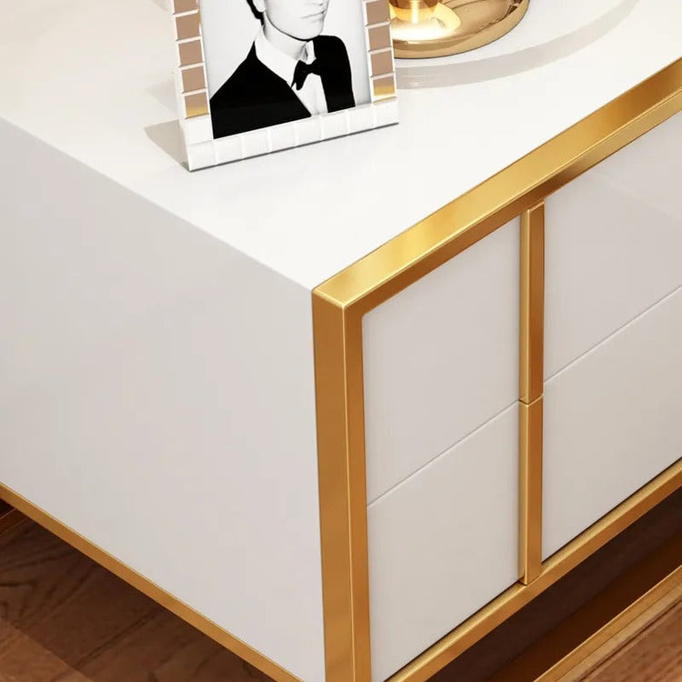 Close-up of a white bedside cabinet top and gold-colored corner trim.