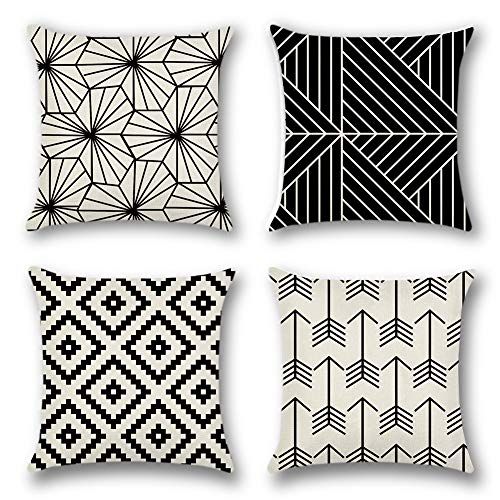 Four black and cream cushion covers with line, diamond and arrow patterns.