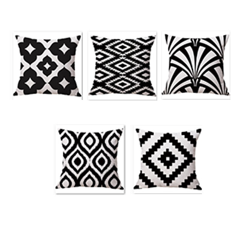 Five black and white cushion covers with diamonds and sweeping leaf-like patterns.