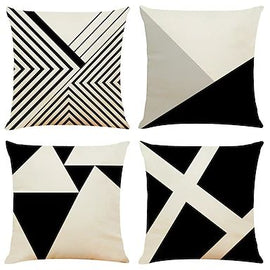 Four black, cream and grey cushion covers with geometric shapes and fine stripes.