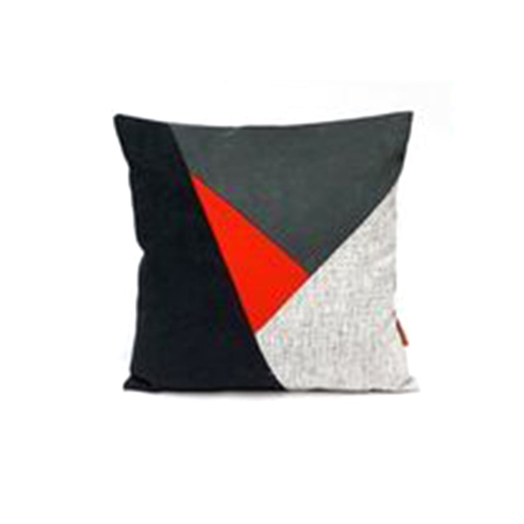 Cushion cover with black, grey and white panels and a red triangle.