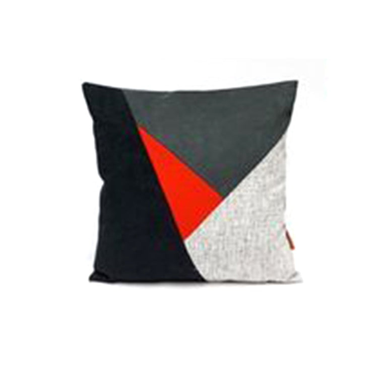 Cushion cover with black, grey and white panels and a red triangle.