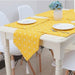 Yellow geometric-pattern table runner with matching placemats on a white dining table.